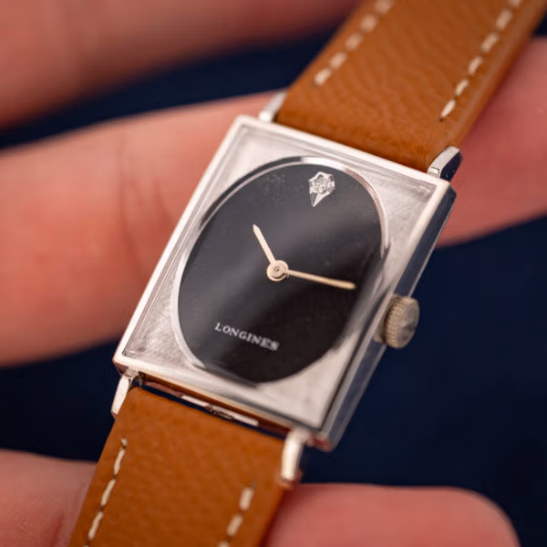 Longines-Wittnauer 3007-528 in hand angled, diamond marker and baton hands on black oval dial