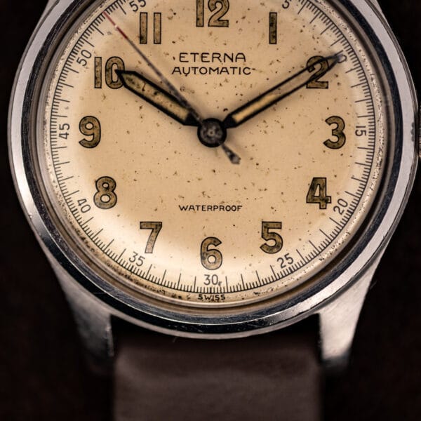Eterna bumper automatic full dial, Arabic numerals on railroad track, SWISS at the foot, speckled patina