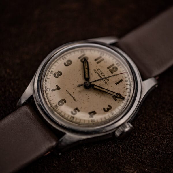 Vintage Eterna Cal. 835 three-quarter view on brown suede, fluted crown at three, fixed steel bezel