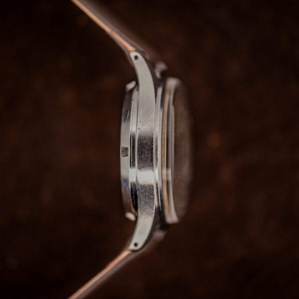 Eterna automatic bumper case band side view, brushed stainless mid-case with light honest wear