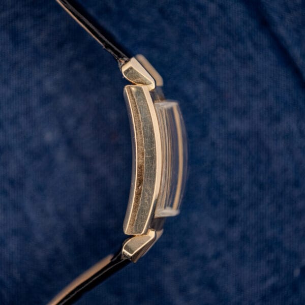Omega N-6243 side profile showing tall domed acrylic crystal and curved-to-wrist gold filled case