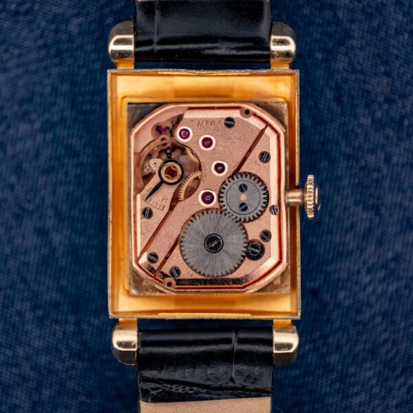 Omega caliber 302 copper-gilt manual movement seen through the open caseback of the N-6243 Tank