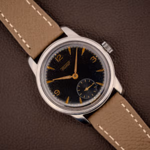 Vintage Tissot ref. 6769 black gilt dial with gold Arabic numerals and dauphine hands on mud grey leather strap