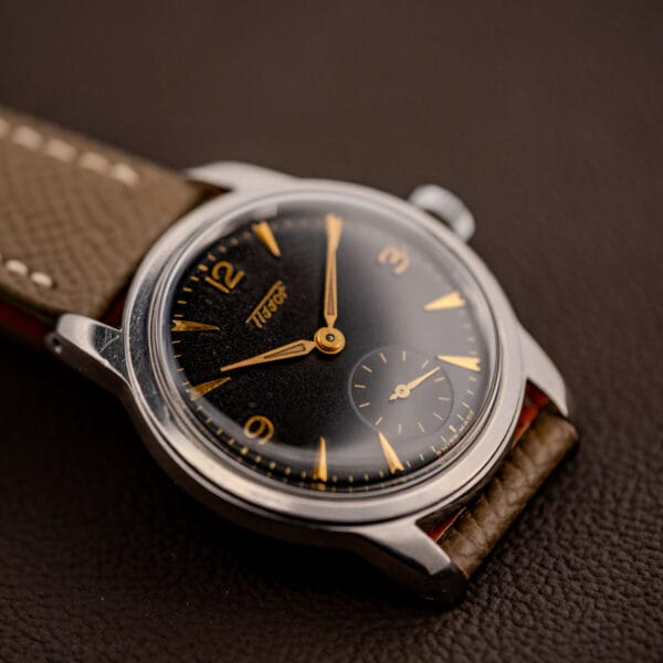 Vintage Tissot 6769 black gilt dial dramatic angle with sub-seconds register and gold dagger markers