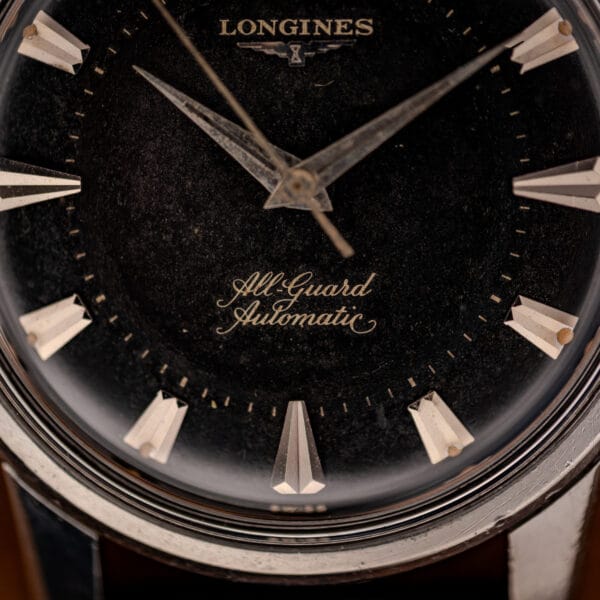 Longines All-Guard Automatic gilt script above six on textured black dial close-up