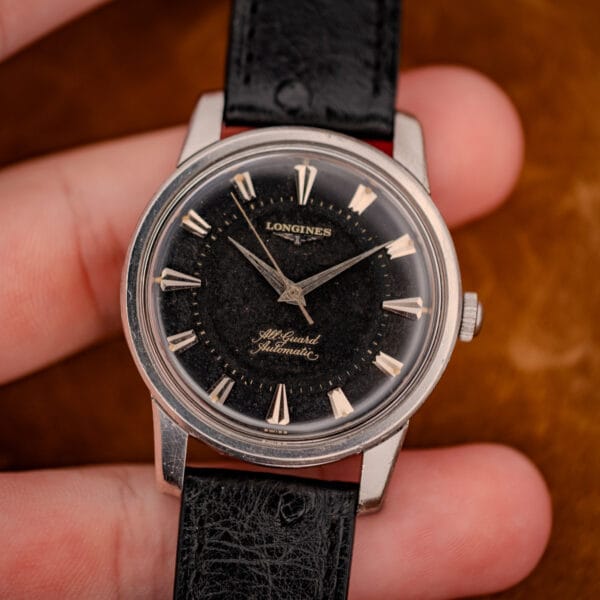 Longines All Guard black gilt dial in hand, SWISS printed at the foot, full front