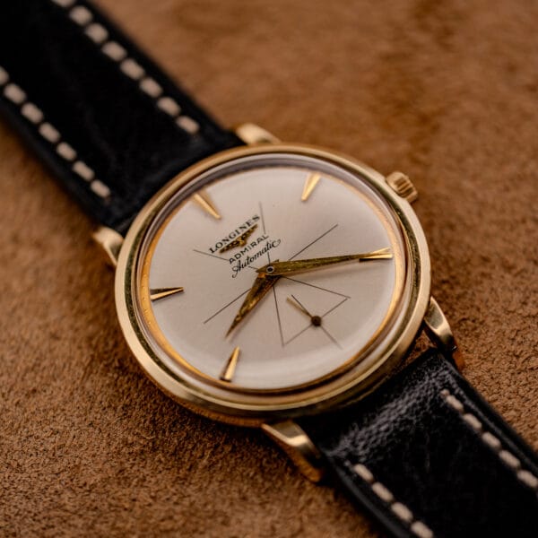 Longines Admiral automatic dress watch photographed at an angle showing silver dial and polished gold filled bezel