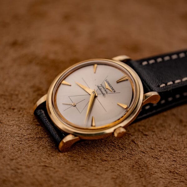 Vintage Longines Admiral automatic ref. 69-240 resting on suede showing silver dial and black leather strap