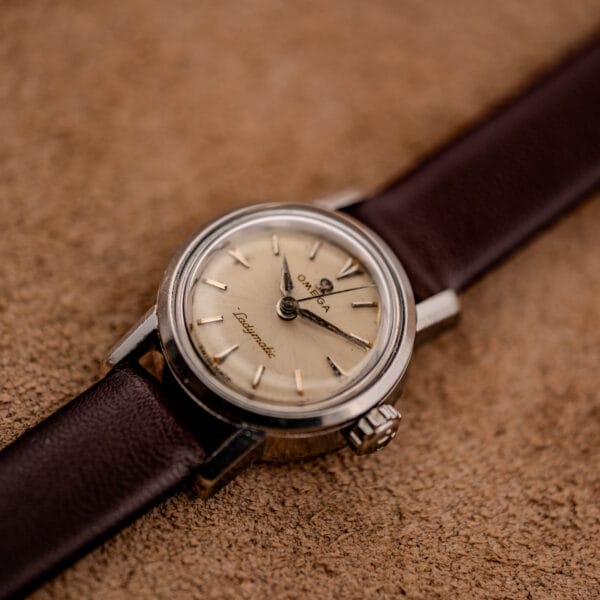 Omega Ladymatic 11000-7 three-quarter view with signed Omega crown and dark brown leather strap