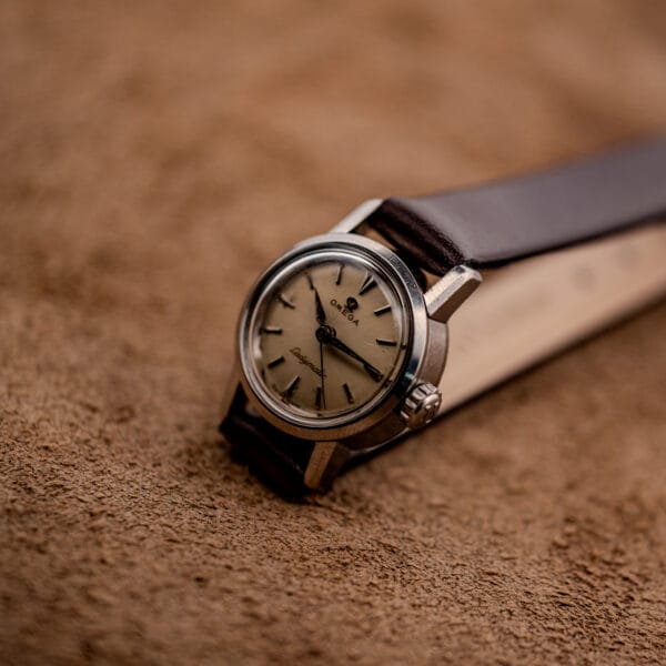 Omega Ladymatic ref. 11000-7 standing upright showing the compact stainless case and brown strap