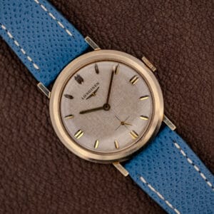 Vintage Longines Ref. 1116 white linen textured dial with gold faceted markers on a blue leather strap