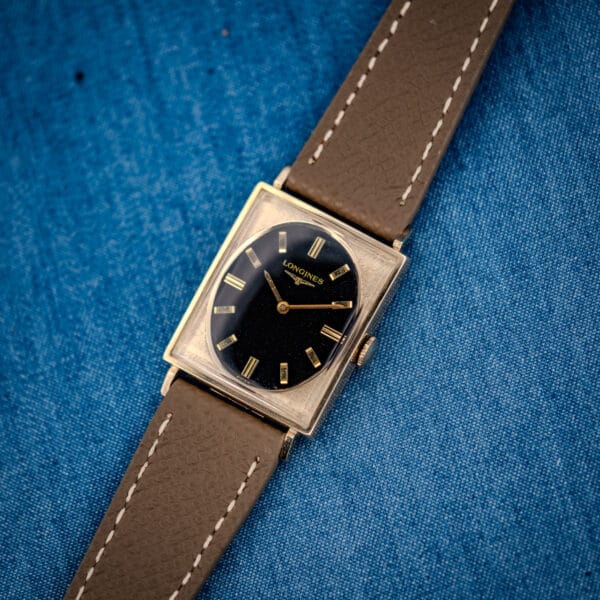 Vintage Longines Tank 3007-528 angled view, oval black gilt dial and florentine-textured gold-filled case