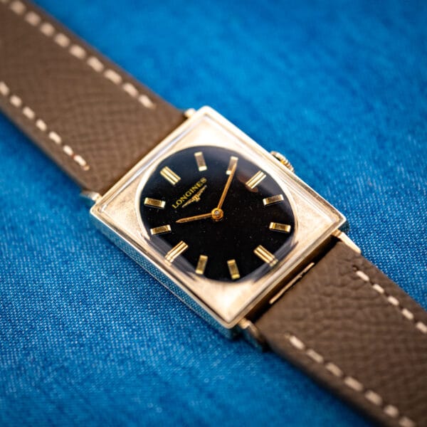 Longines 3007-528 gold-filled tank case angled on mud-grey leather strap with black gilt dial