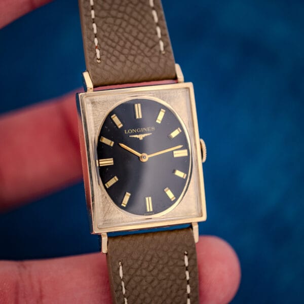Longines Tank 3007-528 angled in hand, applied gold markers and gilt hands on glossy black dial