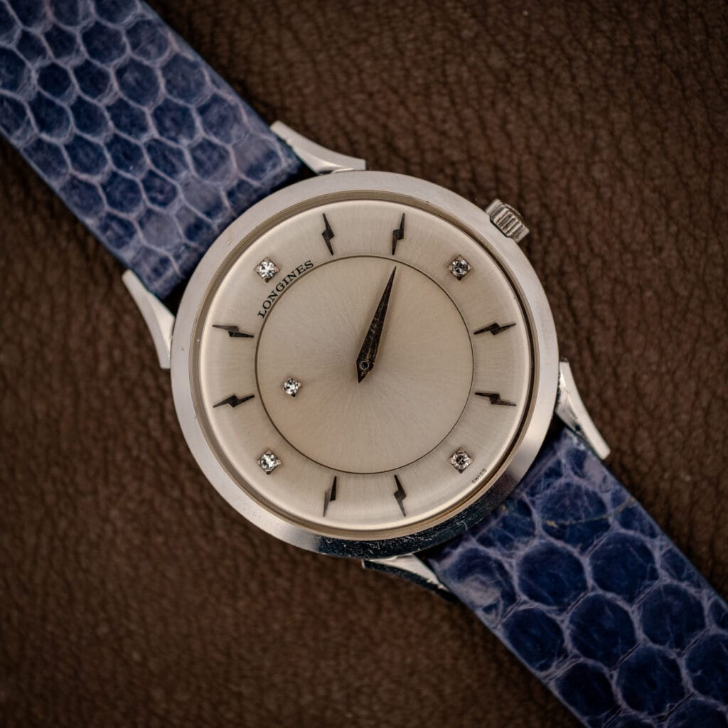 Longines mystery dial 69-230-2A top view, floating dauphine hands over silver sunburst with four diamond markers