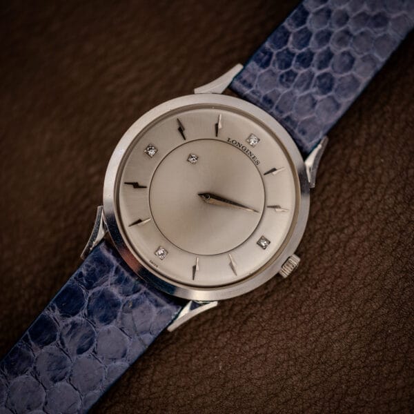 Longines mystery dial 14k white gold case in three-quarter view on a blue snakeskin strap