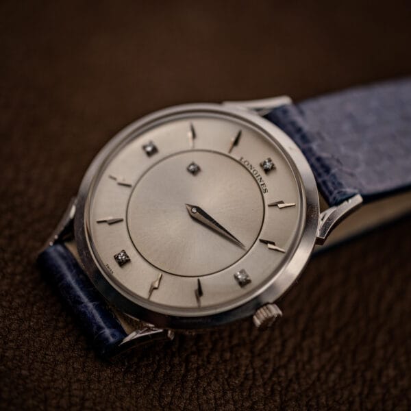 Longines mystery dial three-quarter view, diamond markers and LONGINES signature on silver sunburst