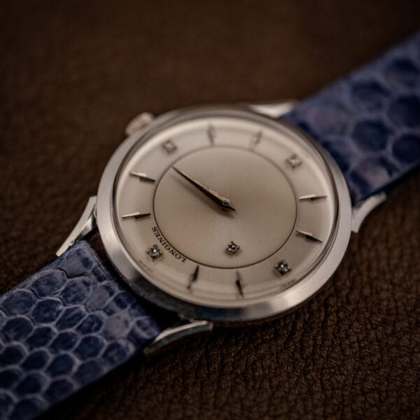 Longines 69-230-2A on a blue snakeskin strap, angled mystery dial with diamond markers
