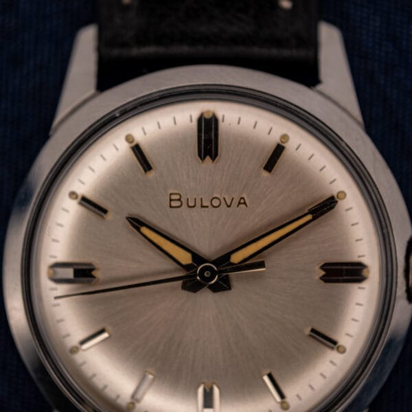 Bulova 11BLC silver sunburst dial macro showing applied faceted baton markers and aged tritium dauphine hands