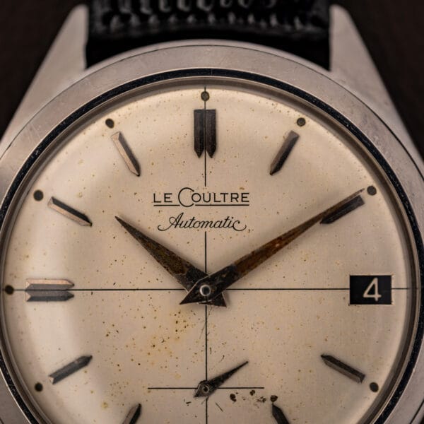 LeCoultre Automatic signature and applied faceted baton markers on aged cream E329 cross-hair dial, close up