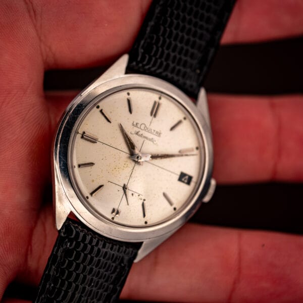 Vintage LeCoultre Automatic E329 stainless watch held in hand showing dial, date and strap
