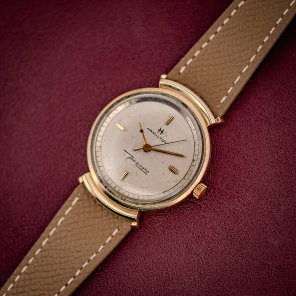 Hamilton Thin-O-Matic 10k gold filled case with integrated hooded lugs on a mud grey leather strap, dial at angle