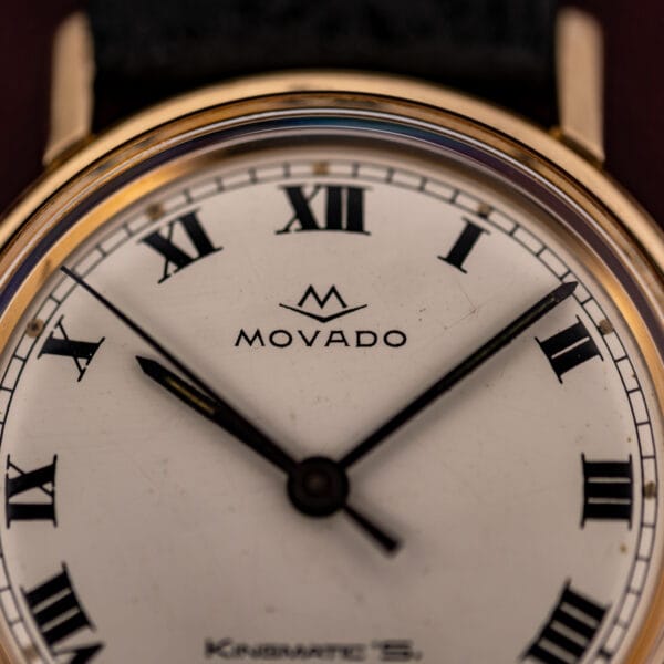 Movado Kingmatic S dial detail, Movado V-logo over MOVADO signature with black Roman numerals on white