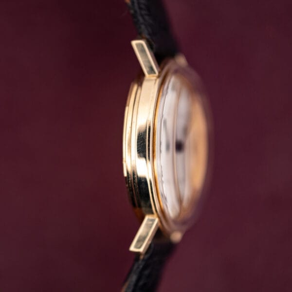 Movado Kingmatic S side profile, faceted lugs and polished gold filled case band on black strap