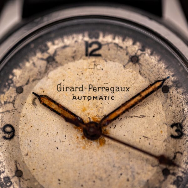 Girard-Perregaux automatic dial close-up showing speckled oatmeal patina and the printed Girard-Perregaux AUTOMATIC signature
