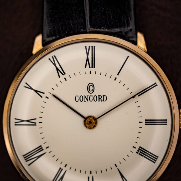Concord white dial close-up signed CONCORD with encircled C logo, black Roman numerals and slim baton hands