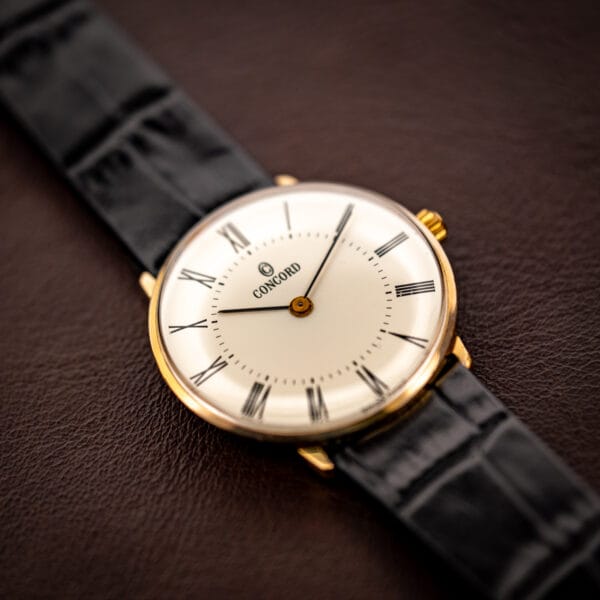 Concord gold plated dress watch three-quarter view, white dial with Roman numerals and gold crown