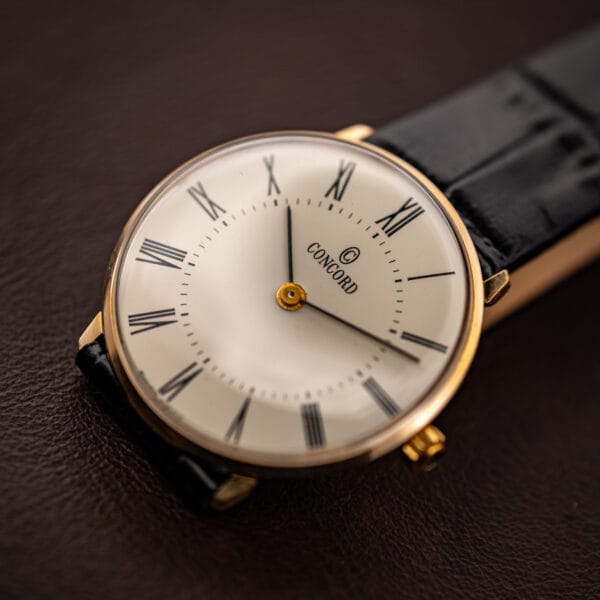 Vintage Concord gold plated watch angled, cream white dial with black Roman numerals and minute track