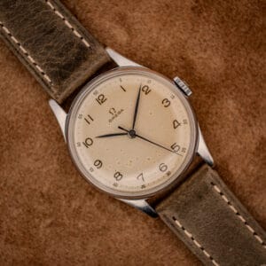 Omega ref. 2391 tropical eggshell dial with Arabic numerals and blued sweep seconds on an olive leather strap