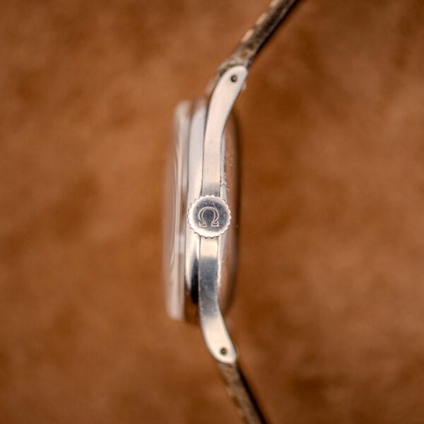 Side profile of the Omega 2391 with signed Omega crown, slim steel case and domed acrylic crystal