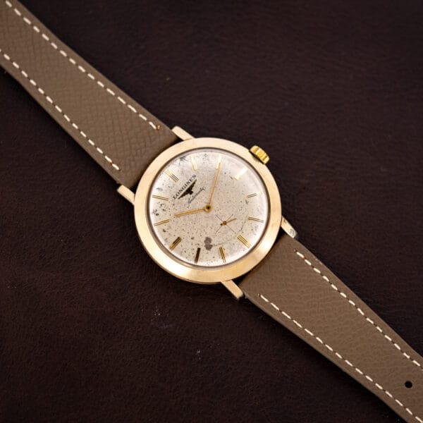 Vintage Longines 2264-1 automatic at an angle, gold filled case on a mud grey leather strap with cream stitching
