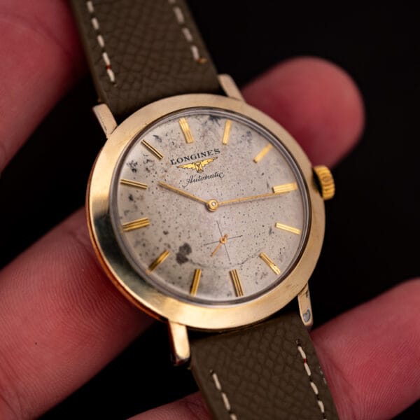 Vintage Longines Automatic 2264-1 in the hand, speckled silver dial and gold filled case caught in daylight