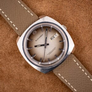 Bucherer 2630/2728 automatic chronometer with champagne ombre dial and day-date, on a mud-grey leather strap