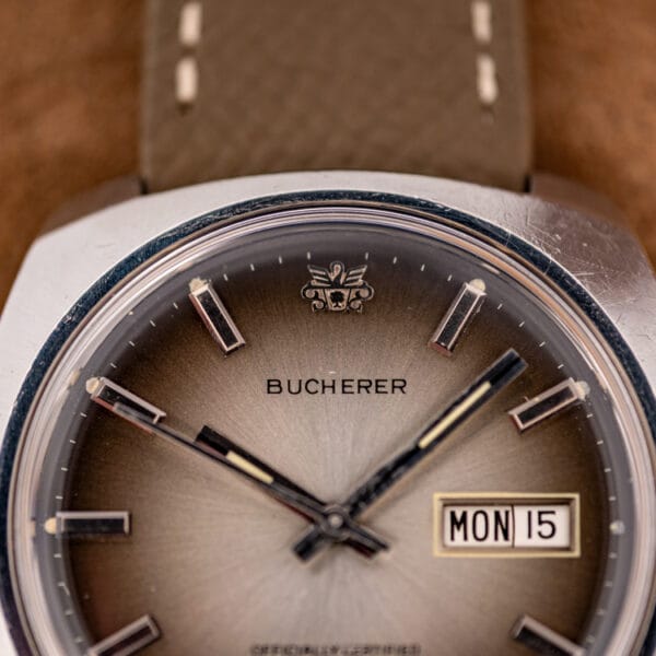 Bucherer dial macro, applied crest and faceted baton markers with tritium plots over a silvered ombre field
