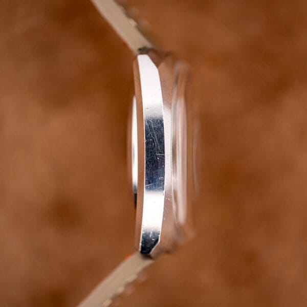 Bucherer cushion case side profile showing the domed acrylic crystal and honest polishing wear on steel