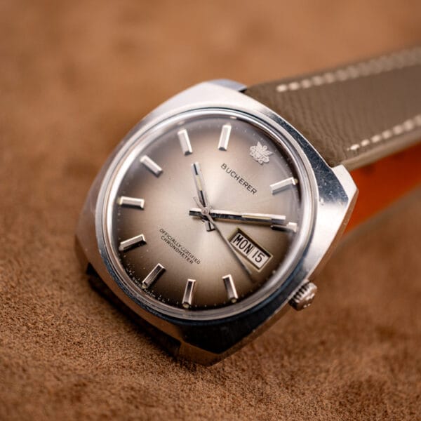 Bucherer 2630/2728 automatic day-date chronometer three-quarter view on a grained mud-grey leather strap