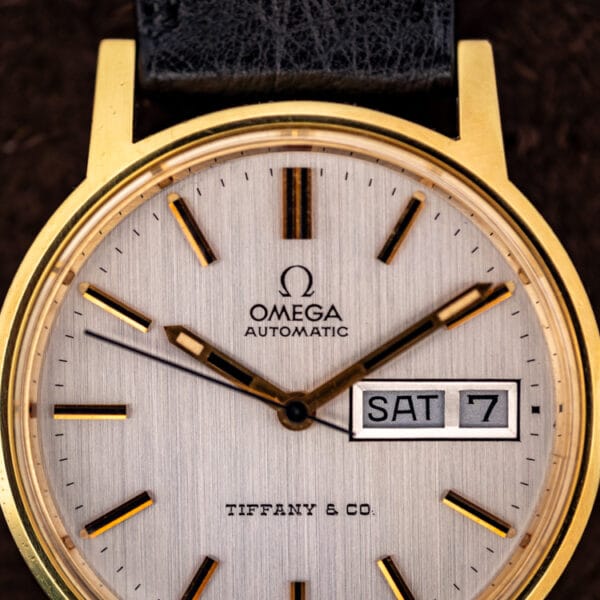Close view of the Omega Tiffany and Co. silver linen dial with the day and date window at three reading SAT 7