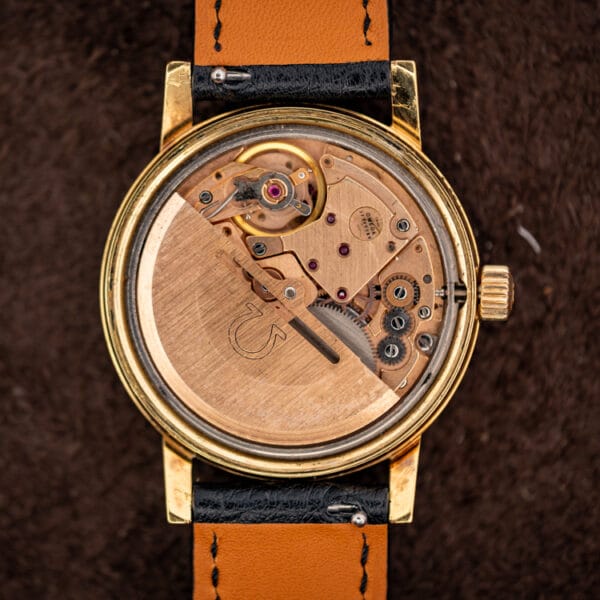 Omega caliber 1012 automatic movement in the case with copper-gilt bridges and a rotor engraved with the Omega symbol