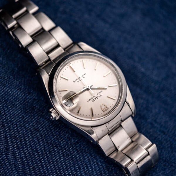 Tudor Prince Oysterdate 74000N angled flatlay, silver dial with date at three on denim