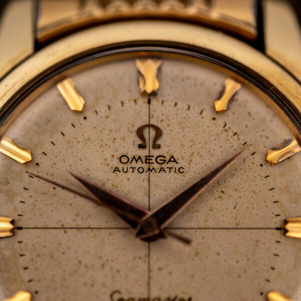 Omega Seamaster 2848 dial macro showing applied Omega logo, OMEGA AUTOMATIC text and freckled cream patina