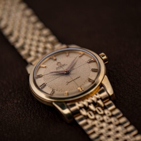 Omega Seamaster 2848 gold-capped three-quarter view with cross-hair cream dial and sweep seconds