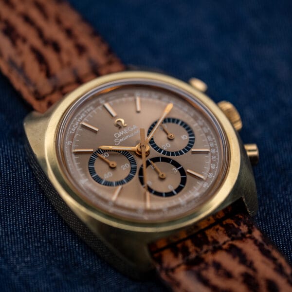 Omega Seamaster 145.029 Bluto chronograph resting on denim, mocha dial and gold-plated tonneau case