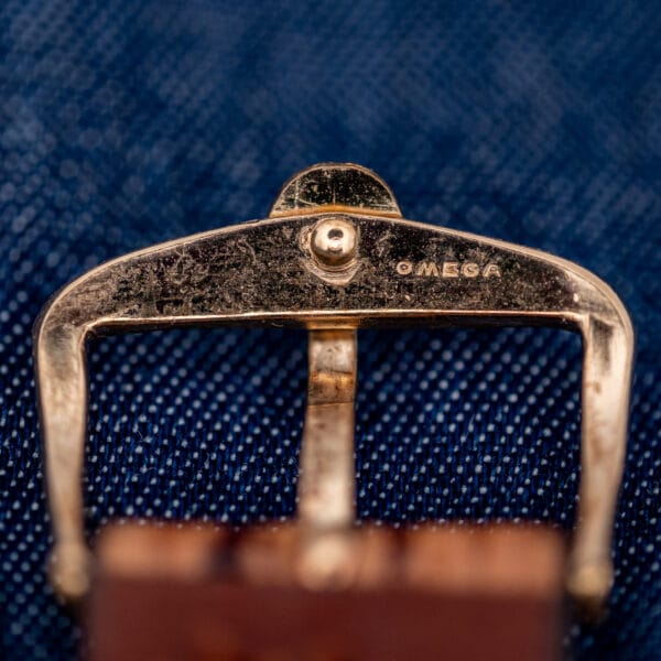 Gold-tone Omega-signed pin buckle stamped OMEGA on the Seamaster 145.029 sharkskin strap