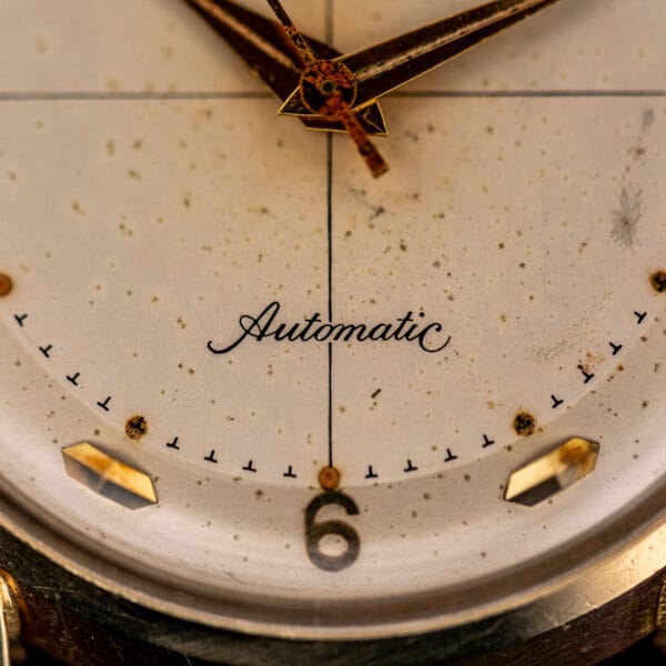 Longines Automatic script above the applied 6 numeral, crosshair center line and speckled age spots across the dial
