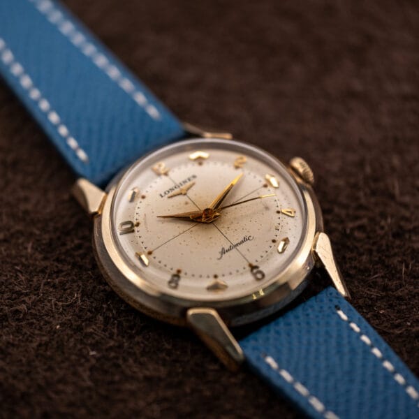 Longines automatic crosshair dial three quarter view, applied gold numerals at the even hours and fluted crown