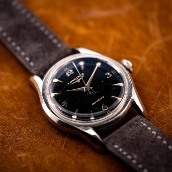 Longines bombe case automatic ref. 6536-1 low angle highlighting the tall domed acrylic crystal over a black dial
